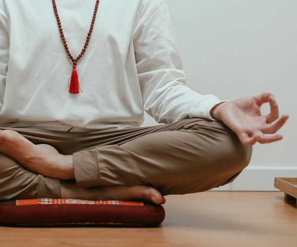 Close-up of a person's hands in a mudra gesture during meditation.